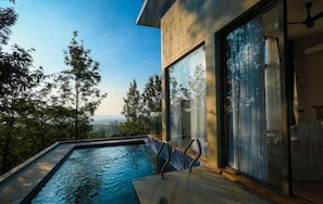 A modern outdoor pool with a view of trees and a distant landscape. - The Zims Luxor Resort (Chikkamagaluru)