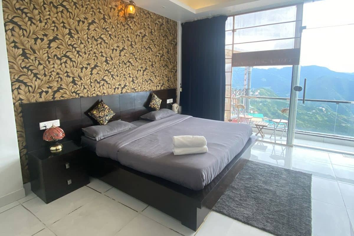 A modern bedroom with a large bed, a nightstand, and a view of the outdoors.