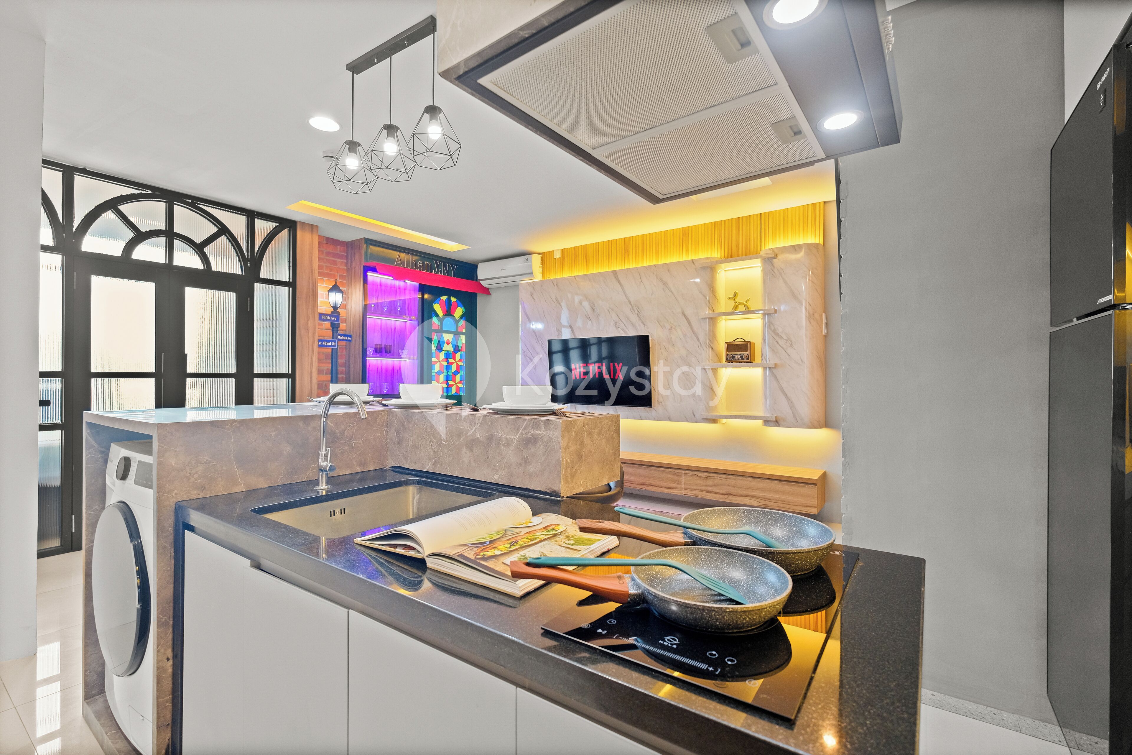 Una cocina moderna con una isla central, electrodomésticos integrados y un amplio ventanal.