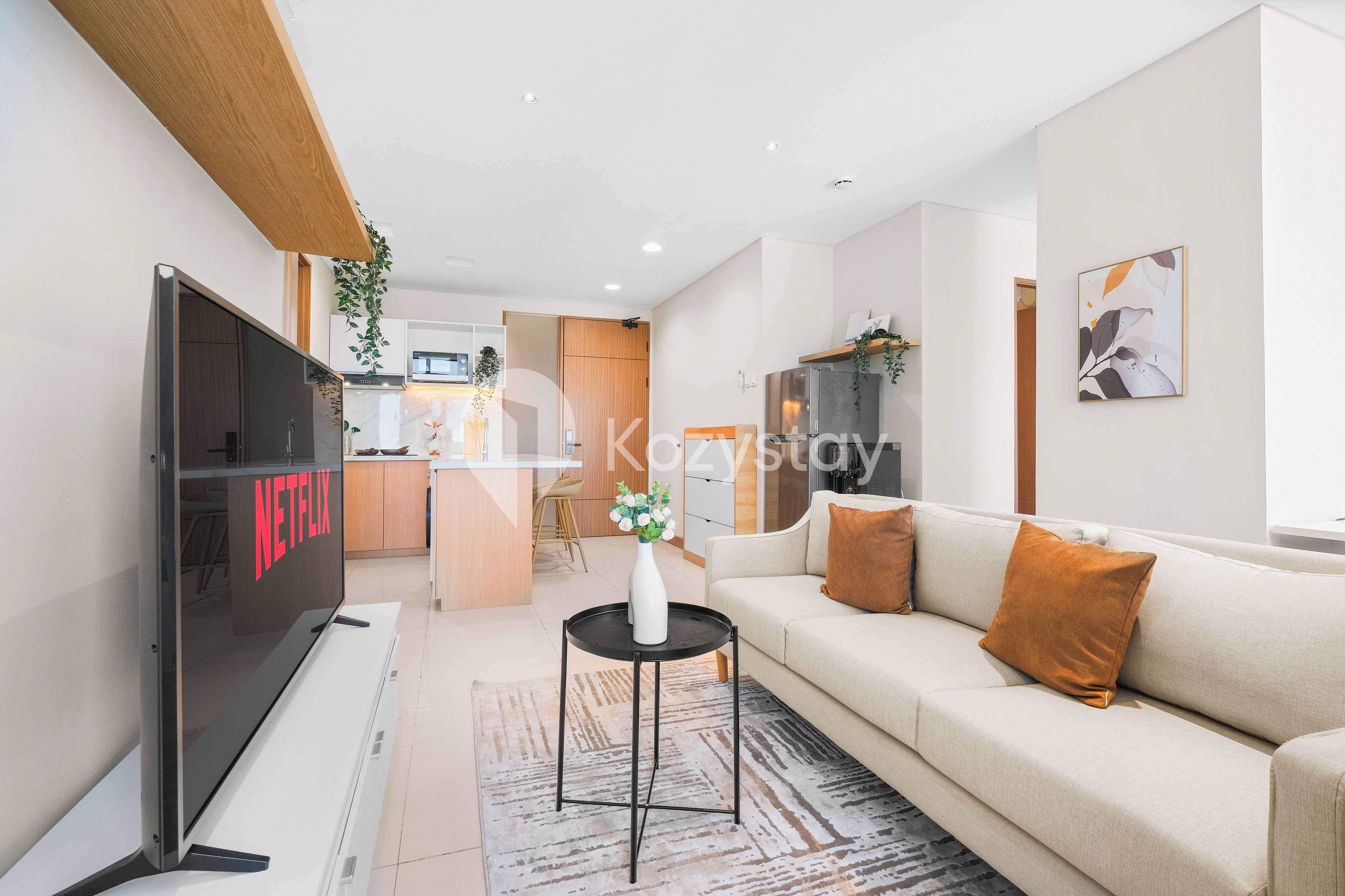 A modern living room with a flat-screen TV, a sofa, and a coffee table.