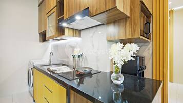 A modern kitchen with wooden cabinets, a black countertop, and a built-in toaster.
