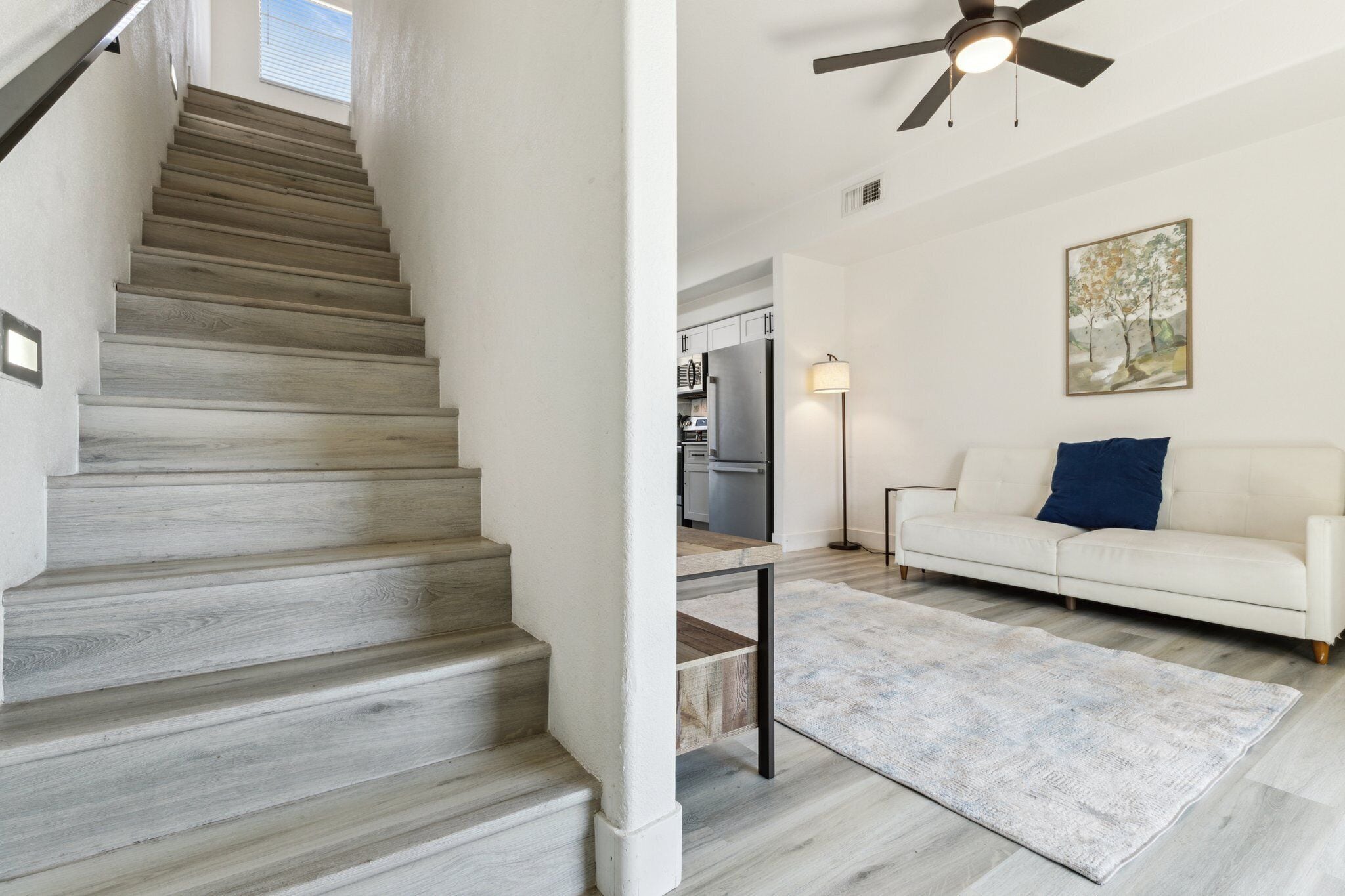 A staircase with wooden steps leading to a kitchen area.