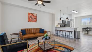 Un salon moderne avec un canapé, une table basse et un tapis aux couleurs vives.