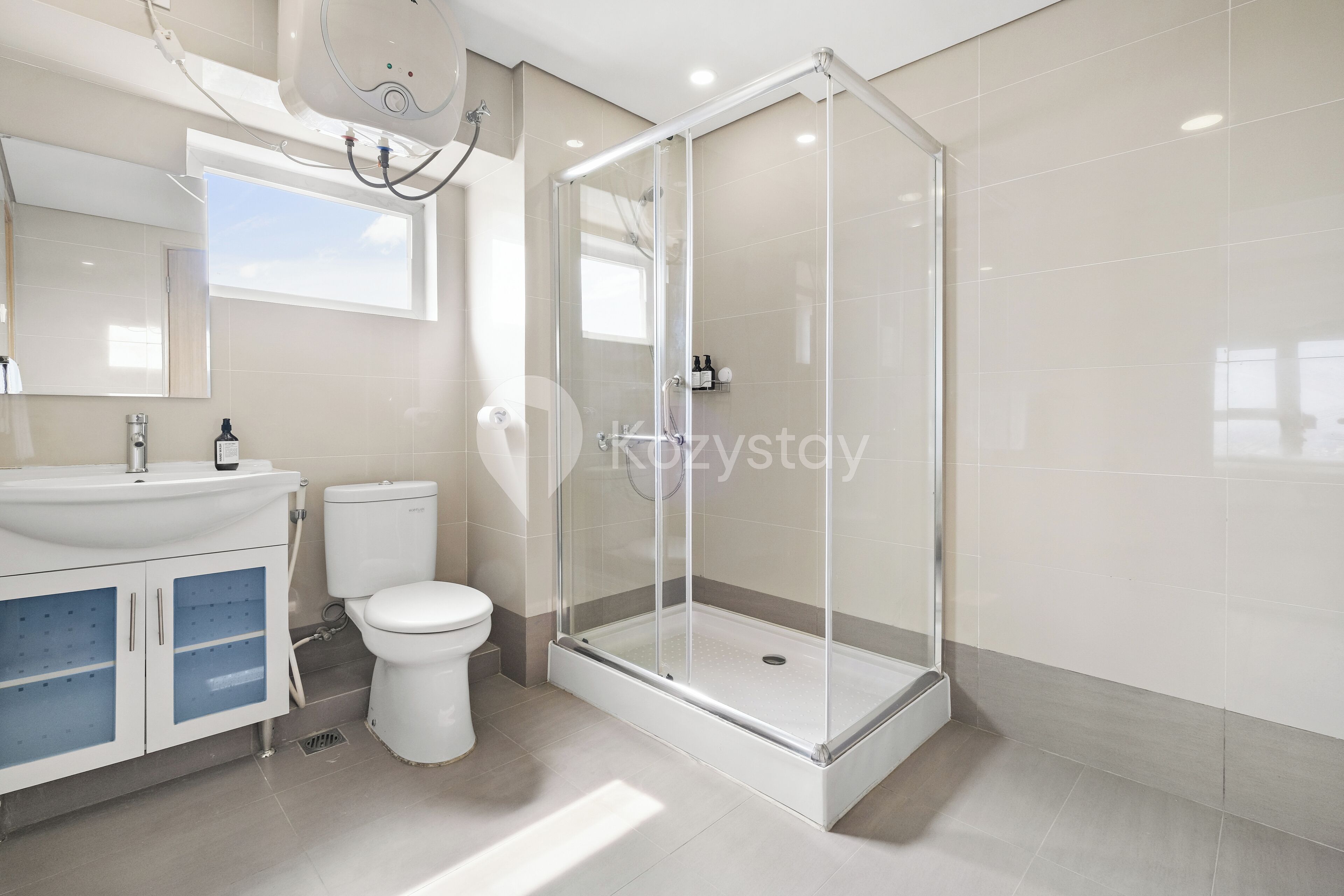 A modern bathroom with a glass-enclosed shower, a white sink, and a toilet.