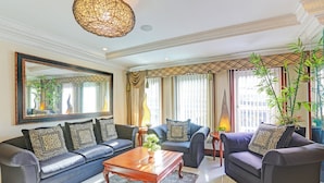 A modern living room with a sofa set, a coffee table, and a large mirror. - VIP Hostel, Evangelista, Makati Manila, Near PNR Pasay (Makati)