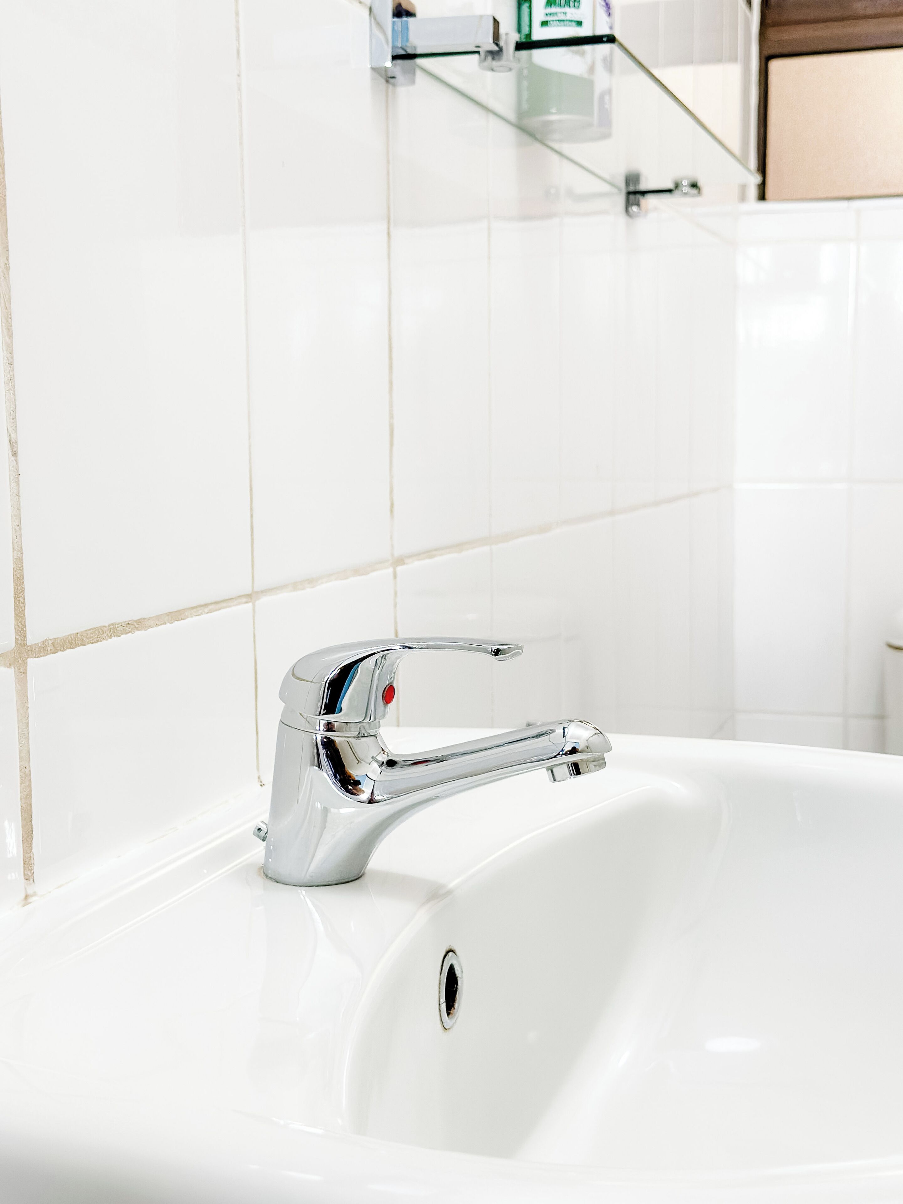 A modern bathroom with a chrome faucet and a white sink.