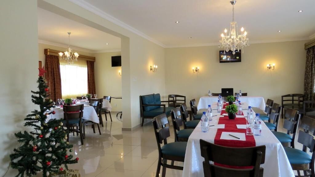 Un comedor con una mesa larga dispuesta para una comida, rodeada de sillas.