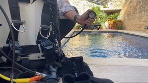 A diver's equipment near a pool with a stone wall and potted plants. - Central House in Sliema with PrivatePool (Sliema)