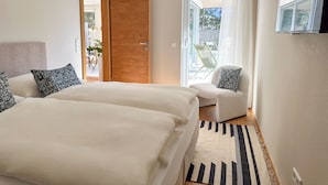 Un dormitorio con dos camas, un sofá y vistas al exterior.