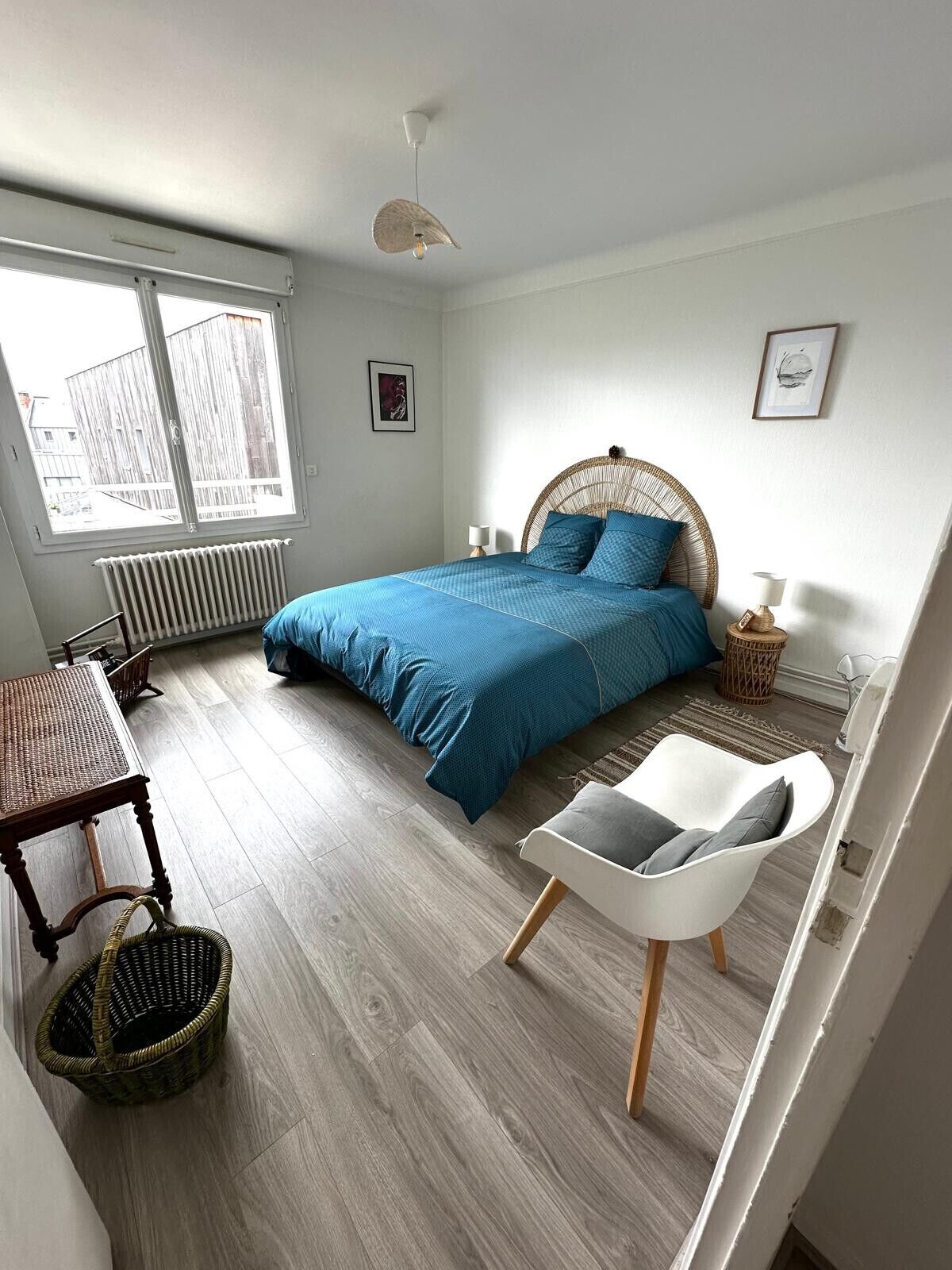 Una camera da letto con un letto, un tavolo, una sedia, un termosifone e una finestra.