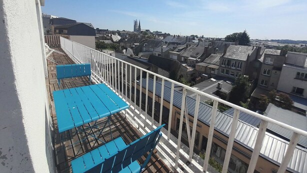 A balcony with blue chairs and a white railing overlooking a residential area with various buildings. - T3 city centre- elevator- parking- panoramic view (Châteauroux)