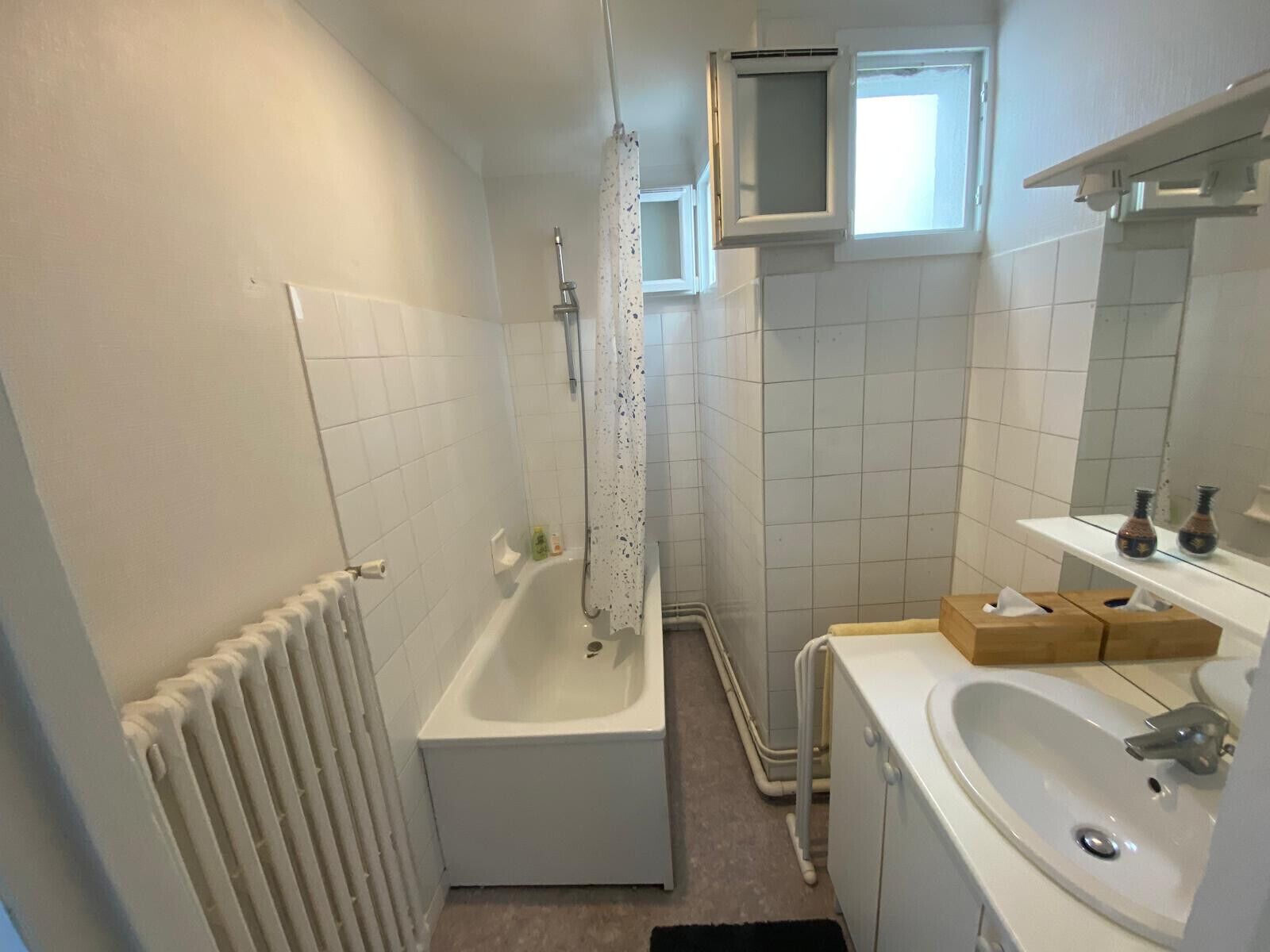 A bathroom with a bathtub, a shower, a sink, and a mirror.