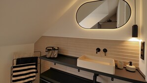 A modern bathroom with a black countertop, a white sink, a mirror, and a towel rack. - Mosel-Herz Trier vacation home! Directly on the Moselle, 10 min to the city center  (Trier)