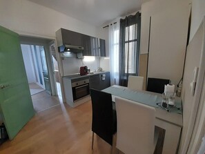 Eine kleine Küche mit Herd, Backofen und modernen Schränken.