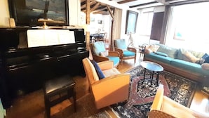 A living room with a grand piano, a television, and comfortable seating. - Chtx, belle maison de ville 4 chb cour privée (Châteauroux)