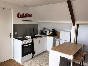 A compact kitchenette with a stove, oven, microwave, and a small refrigerator. - The workshop of dreams - 4 pers - wifi - air conditioning (Châteauroux)