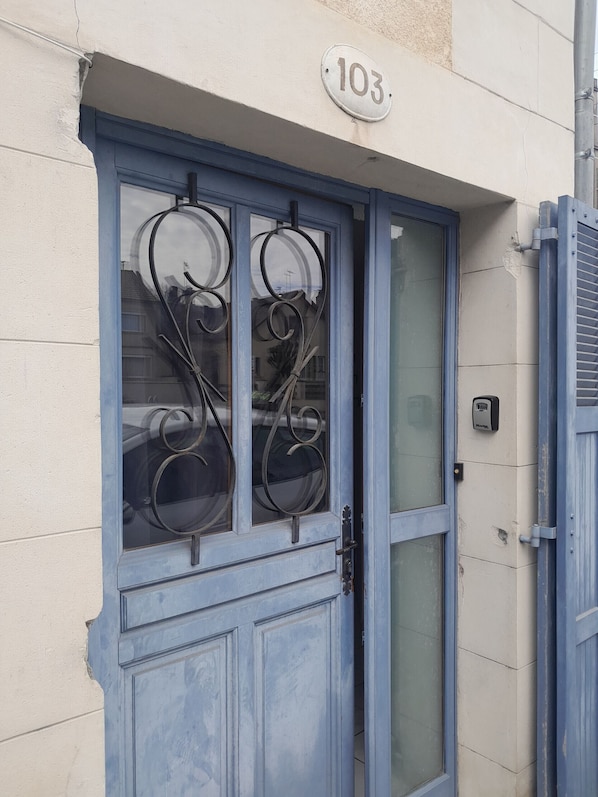 A blue door with a glass panel and a number plate indicating '103'.