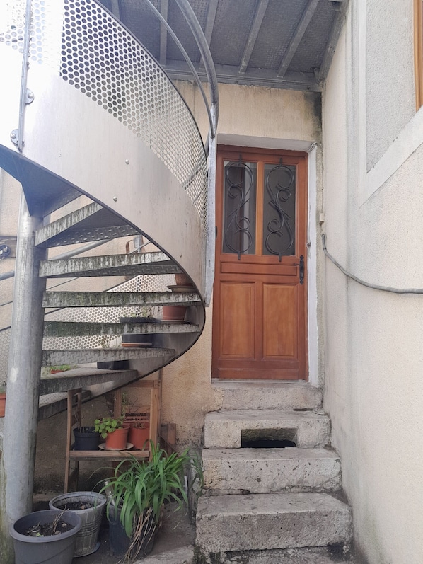 Un escalier en colimaçon avec des rampes en métal et des plantes en pot.
