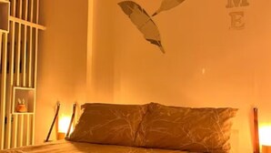 Ein Schlafzimmer mit einem Bett, Kissen und einer Wanddekoration.