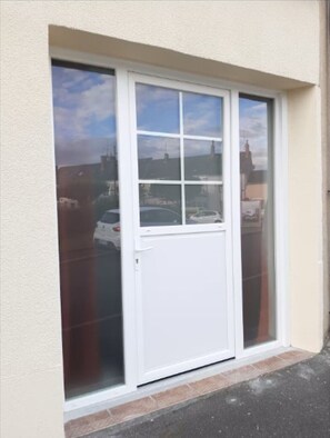 A white sliding glass door with a clear view of the street outside.