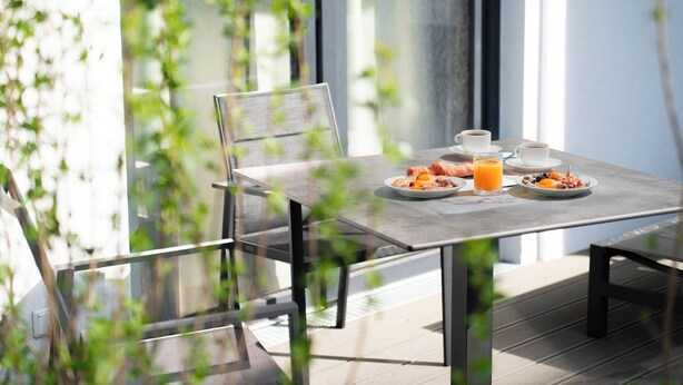 A dining table with plates of food, a glass of orange juice, and a cup of coffee.