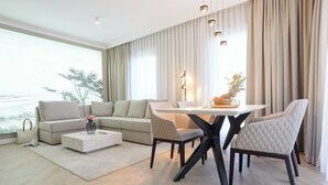 A modern living room with a sofa, coffee table, dining table, and chairs.