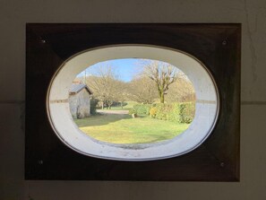 A square window with a round glass pane.