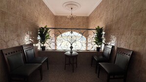 A room with a tiled floor, two chairs, a small table, and two potted plants. - Eqamh Etlala Quba- إقامة إطلالة قباء (Madinah)