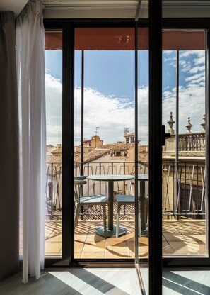 Un balcon donnant sur un paysage urbain, avec une table et des chaises.