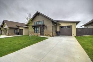 A modern two-story house with a covered garage, a well-maintained lawn, and a concrete driveway.