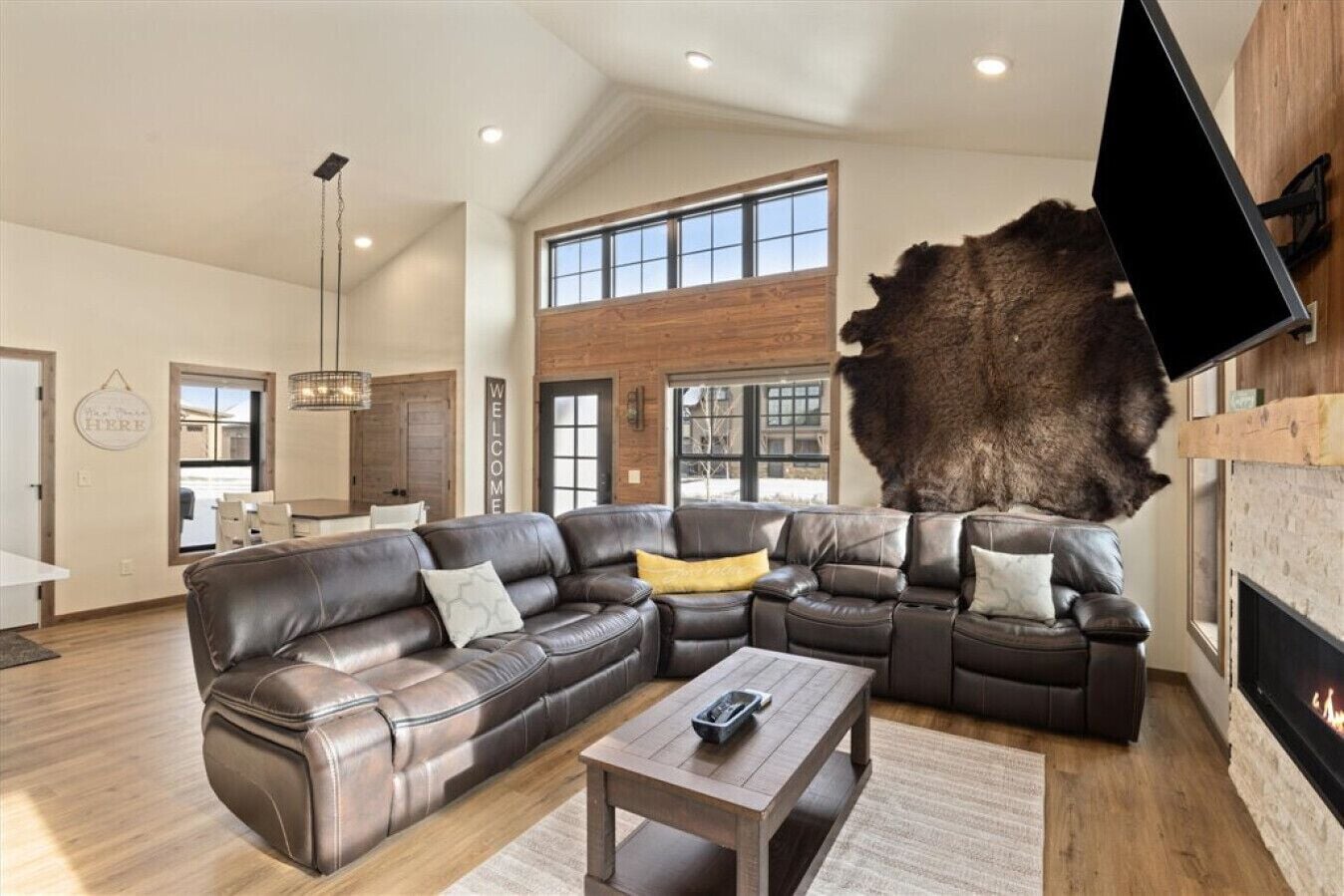 A spacious living room with a large sectional sofa, a coffee table, and a fireplace.