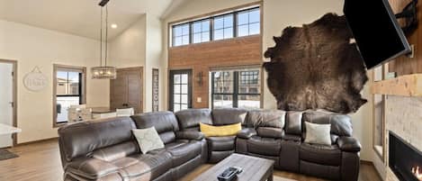 A spacious living room with a large sectional sofa, a coffee table, and a fireplace.