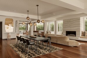 A spacious living area with a dining table, chairs, and a fireplace. - Oceanfront Retreat on Belmore (Sunshine Beach)