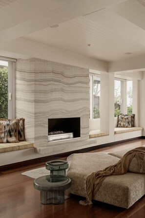 A modern living room with a fireplace, a sofa, and a coffee table.