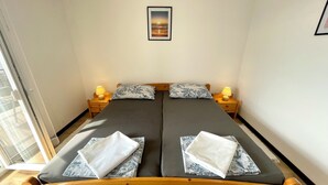 Una cama doble con dos almohadas, una mesita de noche con una lámpara y un cuadro en la pared.