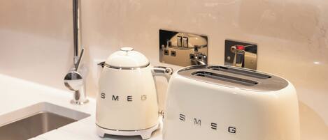 A kitchen with a modern sink, a toaster, and a coffee maker.