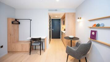 Un espacio habitable moderno y funcional, con kitchenette, comedor y zona de estar.