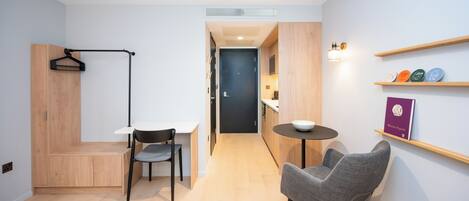 Un espacio habitable moderno y funcional, con kitchenette, comedor y zona de estar.