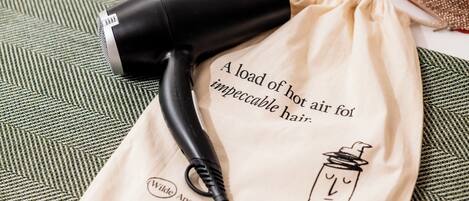 A hairdryer on a beige cloth with text and a logo.