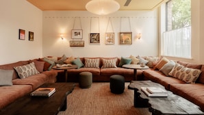 Een gezellige woonkamer met een modulaire bank, een salontafel en een groot raam dat natuurlijk licht biedt.