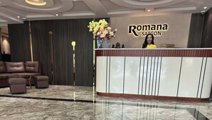 Un área de recepción con mostrador, un sofá y un jarrón decorativo.