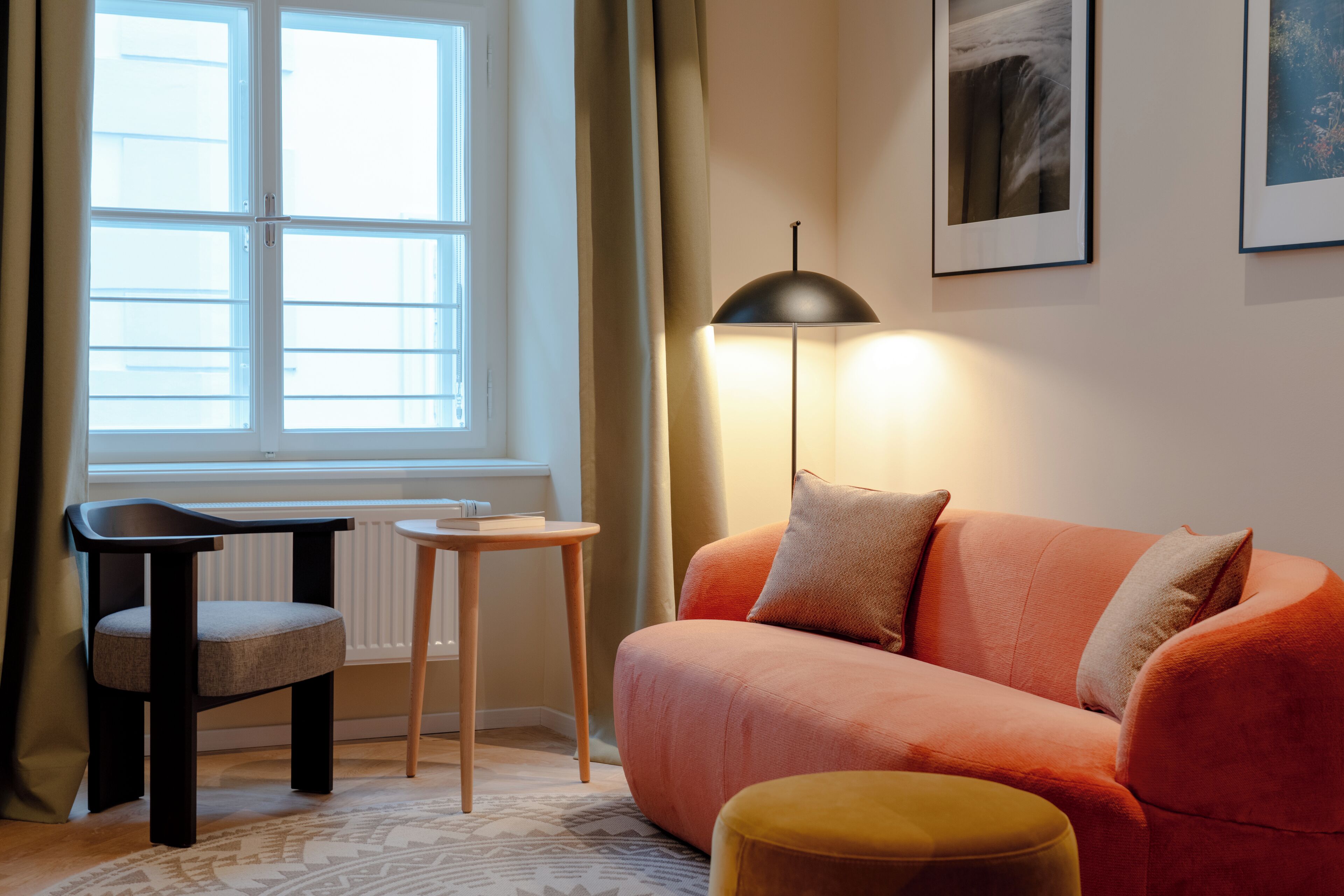 A cozy room with a sofa, a small table, a chair, and a floor lamp.