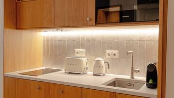 A kitchen with wooden cabinets, a white countertop, a Siemens microwave, a toaster, and a kettle.