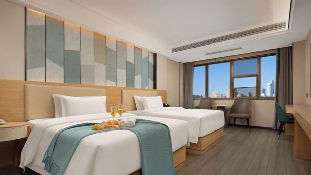 A hotel room with two beds, a desk, and a view of the city. - Hualv Hotel (Guangzhou Children's Hospital Shangxiajiu Pedestrian Street Branch) (Guangzhou)