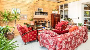 A cozy room with wooden walls, a red patterned sofa, and a wooden cabinet. - Lovely apartment for 2 guests with WIFI, TV, terrace and pets allowed (Neustrelitz)