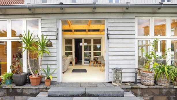 A house with a front porch, steps leading to the door, and potted plants. - Lovely apartment for 2 guests with WIFI, TV, terrace and pets allowed (Neustrelitz)