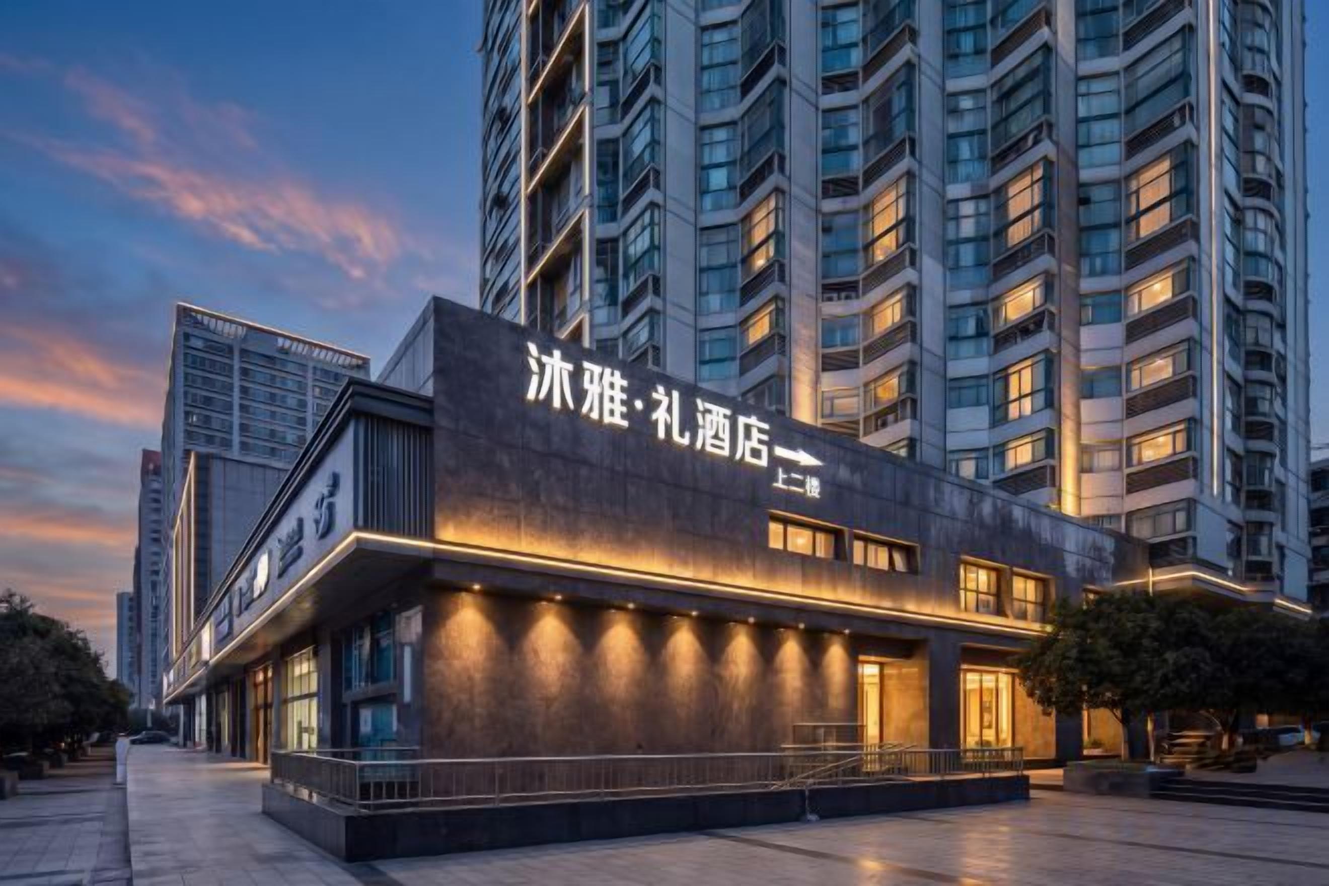 A modern hotel building with illuminated signage, large windows, and a prominent entrance.