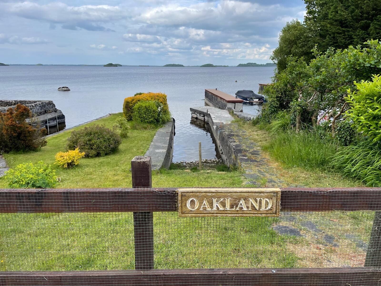 A view of a canal with a wooden sign reading "OAKLAND" and a stone structure in the background.