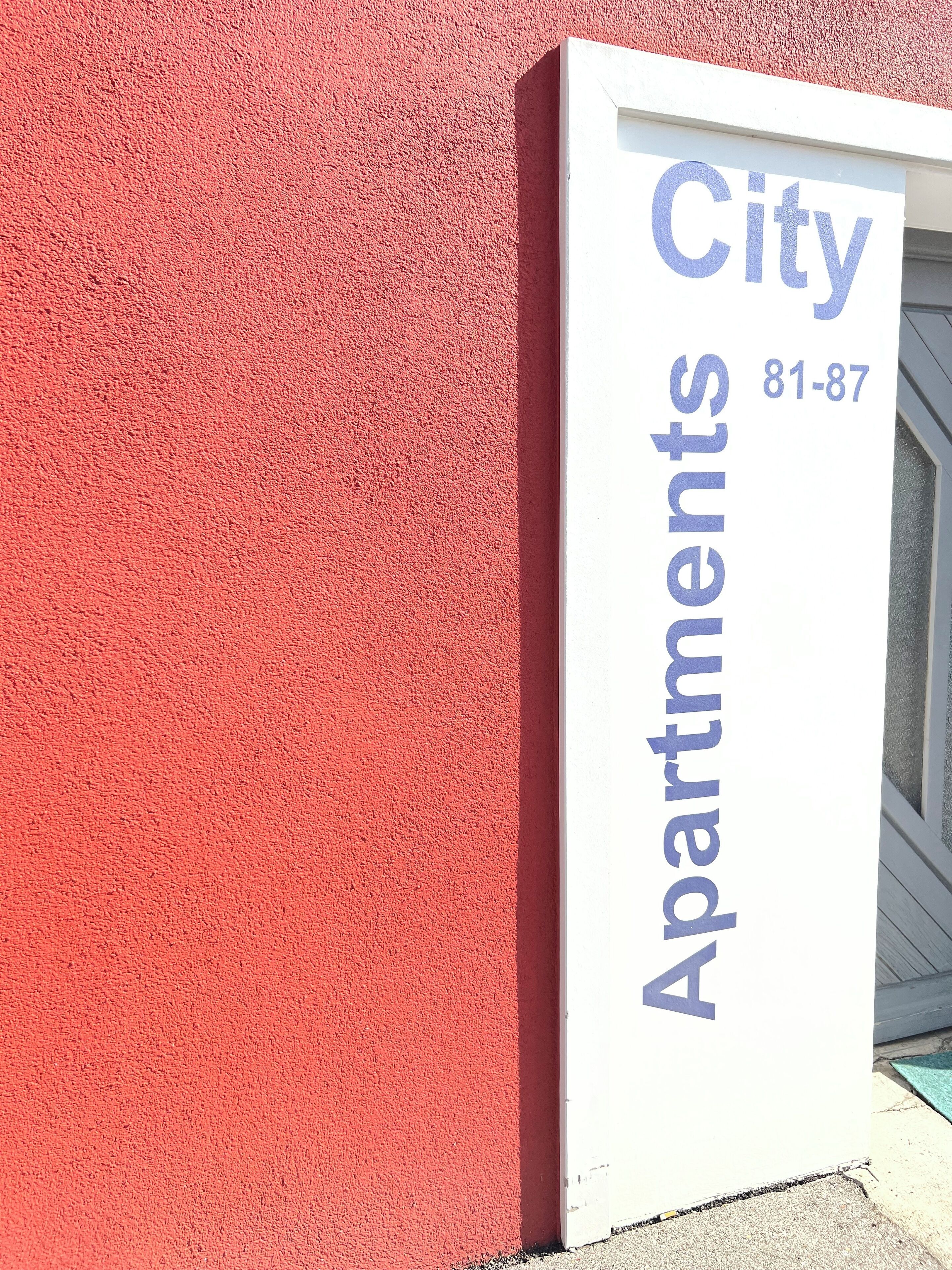 Een bordje voor City Apartments, met het adres 81-87 erop.