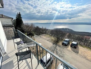 A balcony with a view of a lake and parked cars. - Apartman Ivana i Ante 3 (Crikvenica)